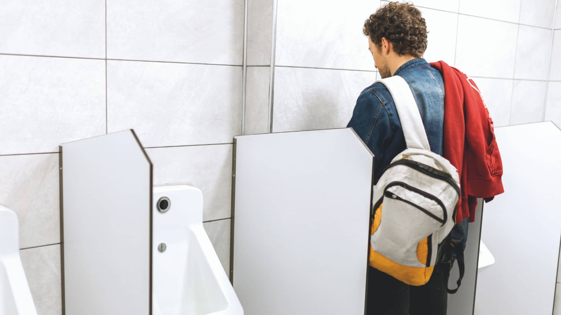 Man Peeing to Urinal in the Restroom