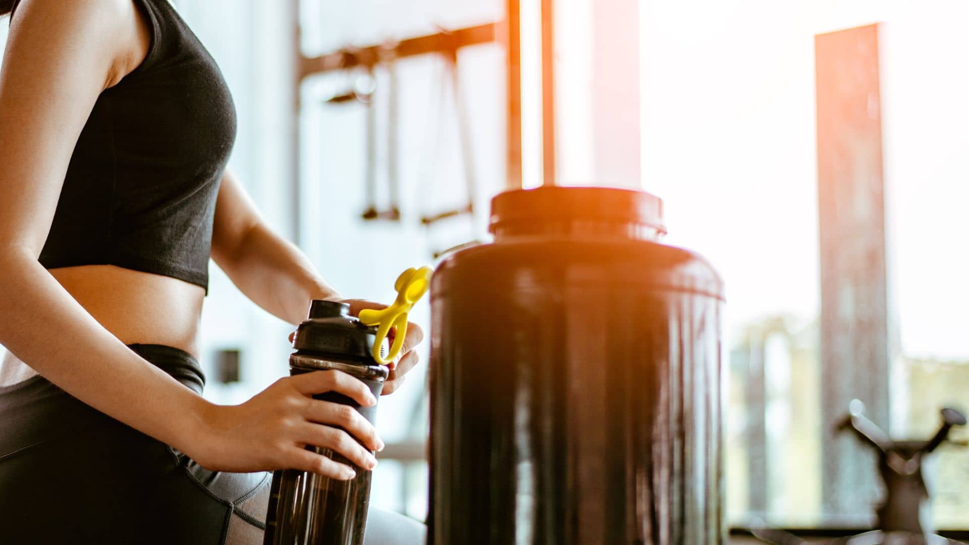 Relaxing after training.beautiful young woman looking away while sitting at gym.young female at gym taking a break from workout.woman brewing protein shake.