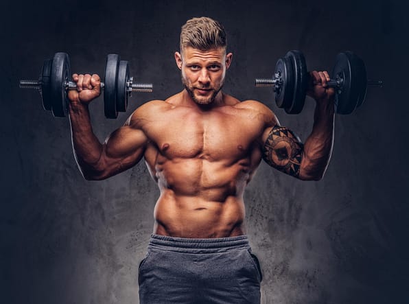 powerful-stylish-bodybuilder-with-tattoo-his-arm-doing-exercises-with-dumbbells-isolated-dark-background.jpg