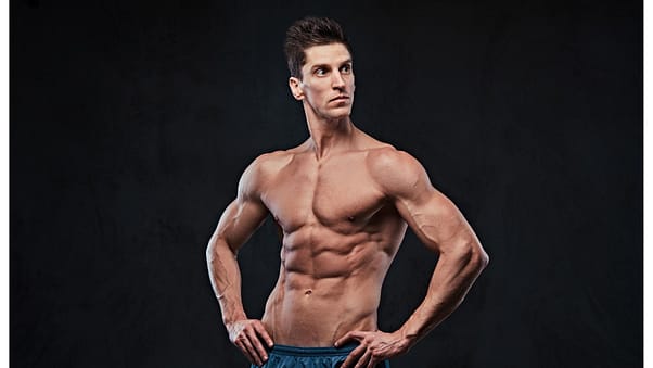 studio-portrait-ectomorph-muscle-shirtless-male-dark-grey-background.jp