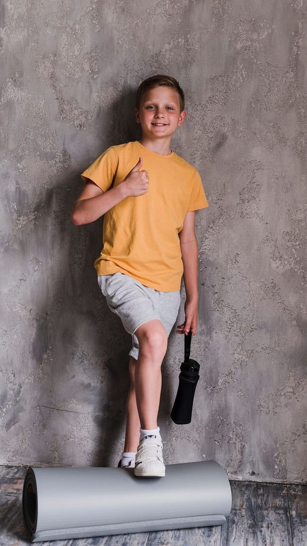 smiling-boy-standing-front-concrete-wall-showing-thumbs-up.jpg