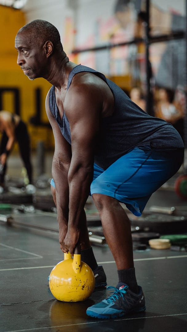 Photo of Man Using Yellow Kettlebell