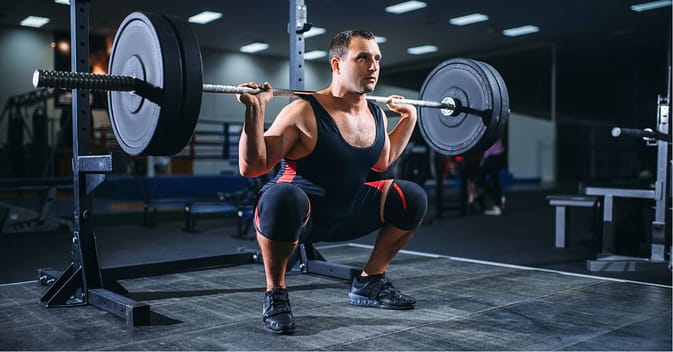 Powerlifter Doing Squats with Barbell in Gym,.