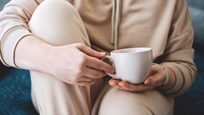 Self care, staying home, cozy mood. Take care of yourself, Love yourself concept. Woman hands with cup of hot drink at home