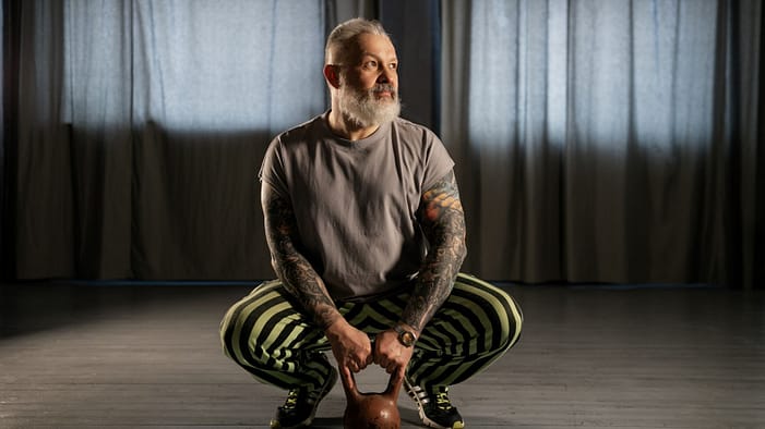 An Elderly Man Holding a Kettlebell