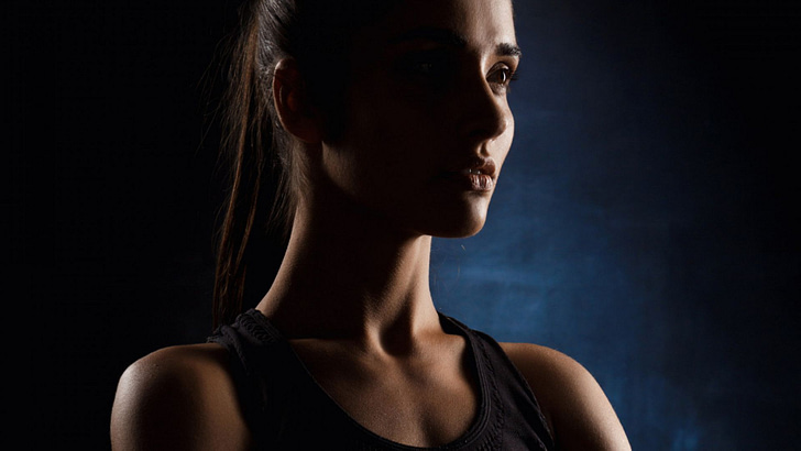 beautiful-sportive-girl-posing-with-crossed-arms-dark-wall..-