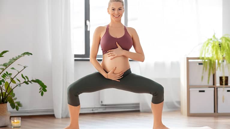 Pregnant Woman Doing Yoga Goddess Squat at Home